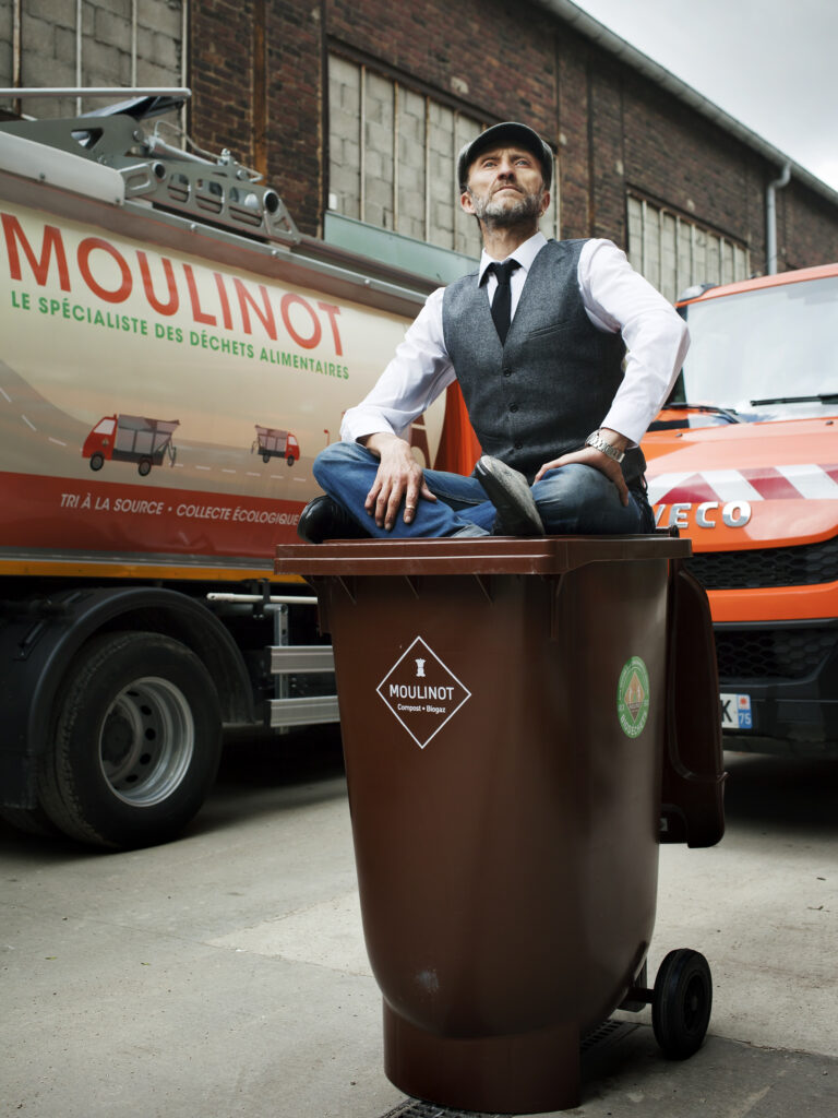 Stéphan Martinez est assis sur une poubelle marron 120L à fond sphérique pour les déchets alimentaires que vous pouvez acheter auprès de Moulinot.